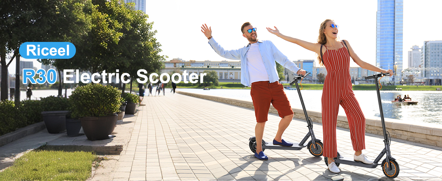 Two people riding Riceel R30 Electric Scooters on a waterfront path. The scooters have a sleek black design with a standing platform and handlebar for steering.