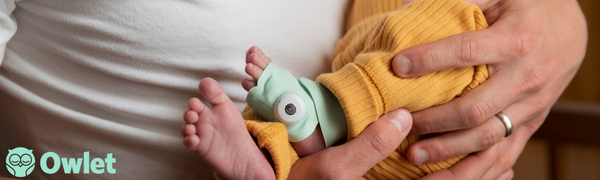 a baby's hand in a yellow sweater