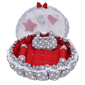 Pink baby lounger with white star pattern and chevron trim, featuring padded sides and cushioned base for infant support.