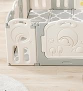Partial view of a white plastic baby safety gate or playpen with built-in interactive elements including colorful shapes and a mirror.