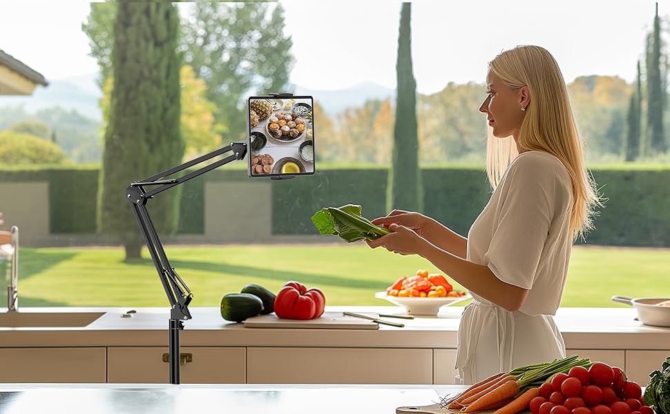 Flexible phone mount arm attached to kitchen counter, showing cooking setup with fresh vegetables and preparation space.