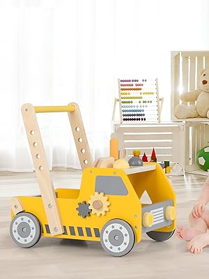 Wooden walker toy in yellow forklift design with gear mechanisms and wheels, shown in a bright indoor setting with decorative elements.