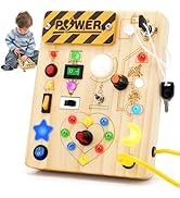 Interactive wooden busy board with various colored buttons, switches, and mechanical elements mounted on natural wood backing.