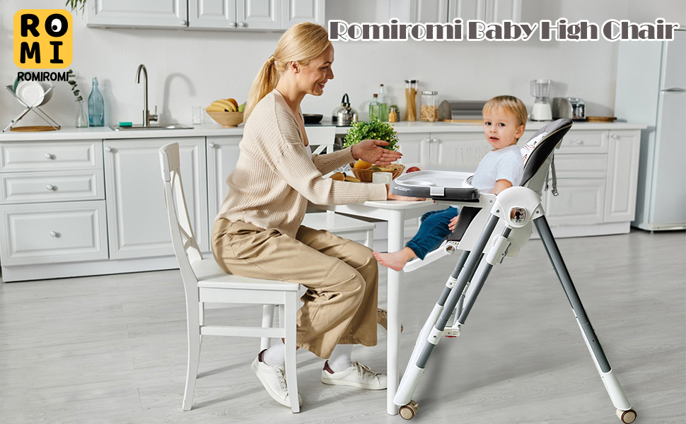 a woman sits at a table with a baby in a high chair.