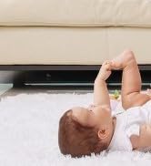 Outdoor scene showing a group gathered around a small metal drum or container in a natural setting.