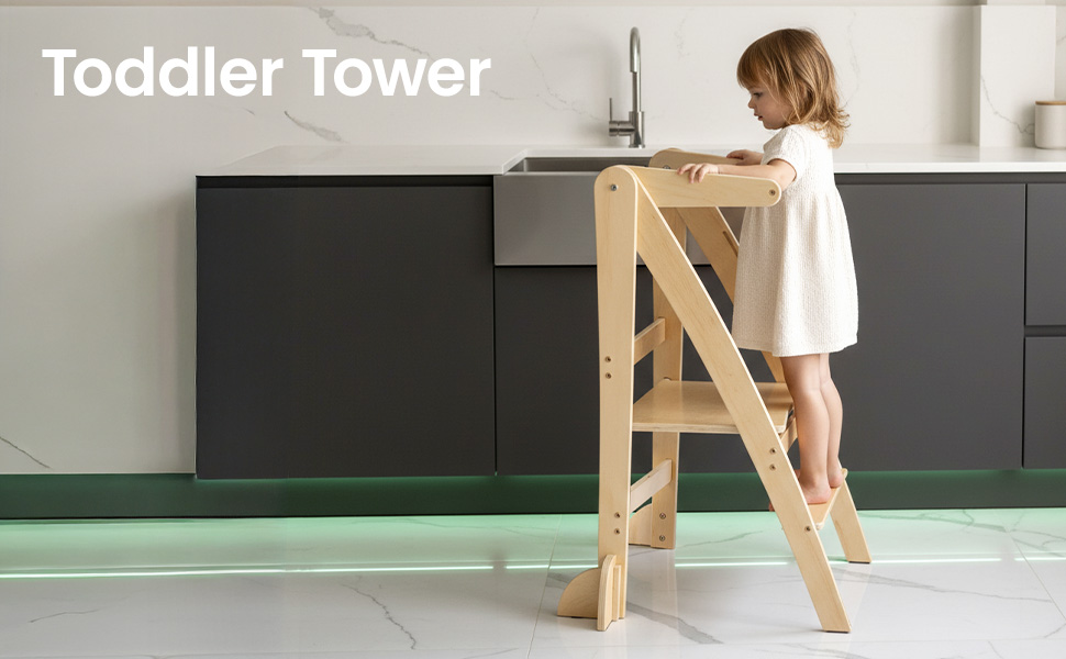 Text reads 'Toddler Tower'. Wooden learning tower or kitchen helper stool shown in natural wood finish against dark cabinet background with mint green flooring.