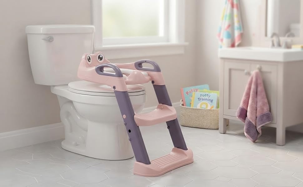 Pink and white toilet training seat with ladder steps in bedroom setting with shelving and potted plant visible.