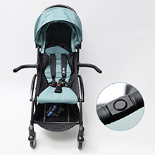 Light blue compact stroller with adjustable canopy and small wheels. Inset image shows a circular control or button detail.