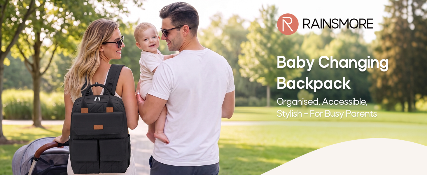 Text reads 'RAINMORE' 'Baby Changing Backpack' 'Organise Pockets'. Woman and man in outdoor park setting wearing black backpack designed for diaper changing and baby care storage.