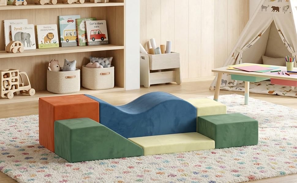 Modular foam play structure with green and blue cushioned sections arranged on patterned floor in bright room with sailboat decoration.